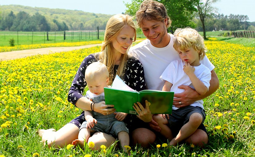 familie leser bok ute